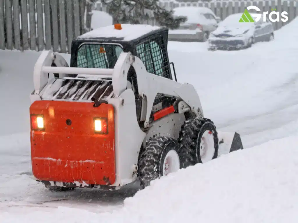 Snowplow clearing a parking lot.