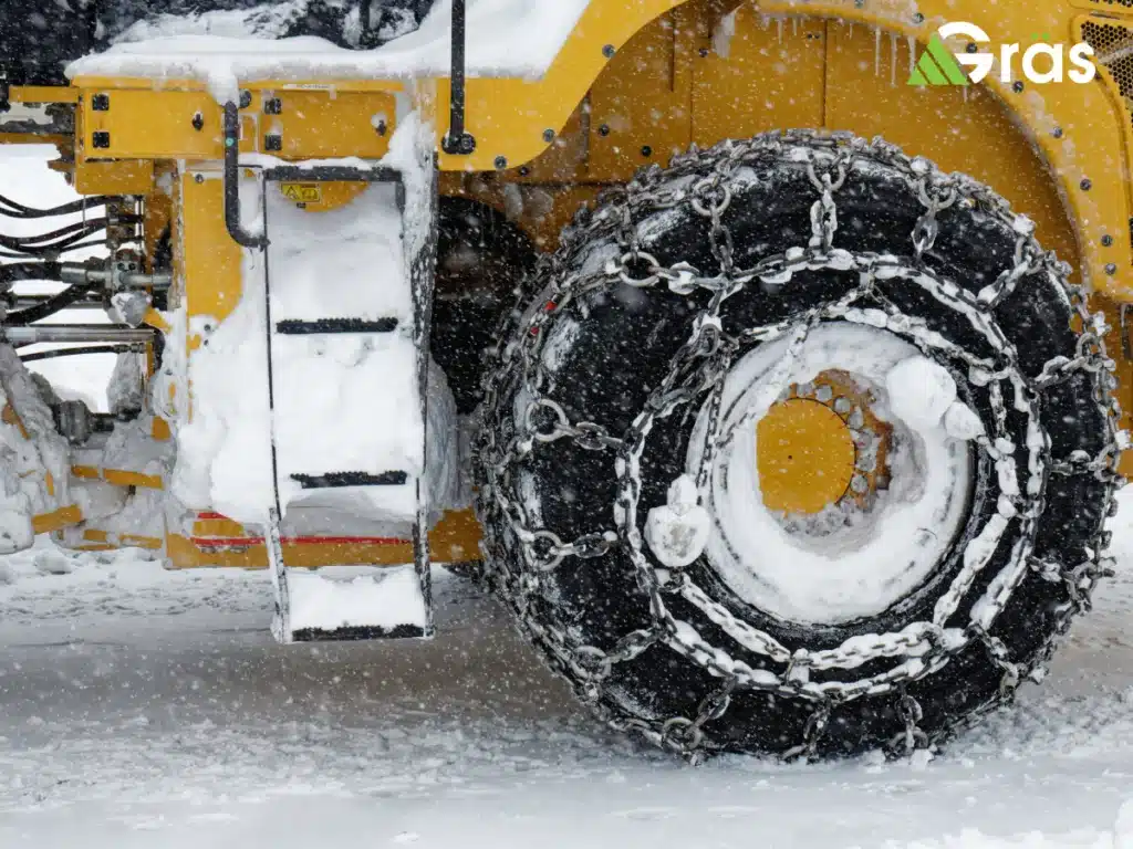 Snowplow tire with chains in a snowstorm.